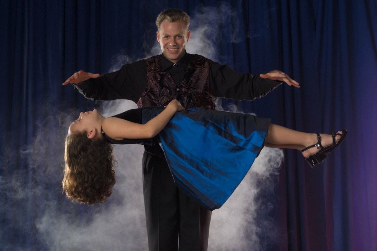 Brock Edwards performing a floating illusion during a school magic show
